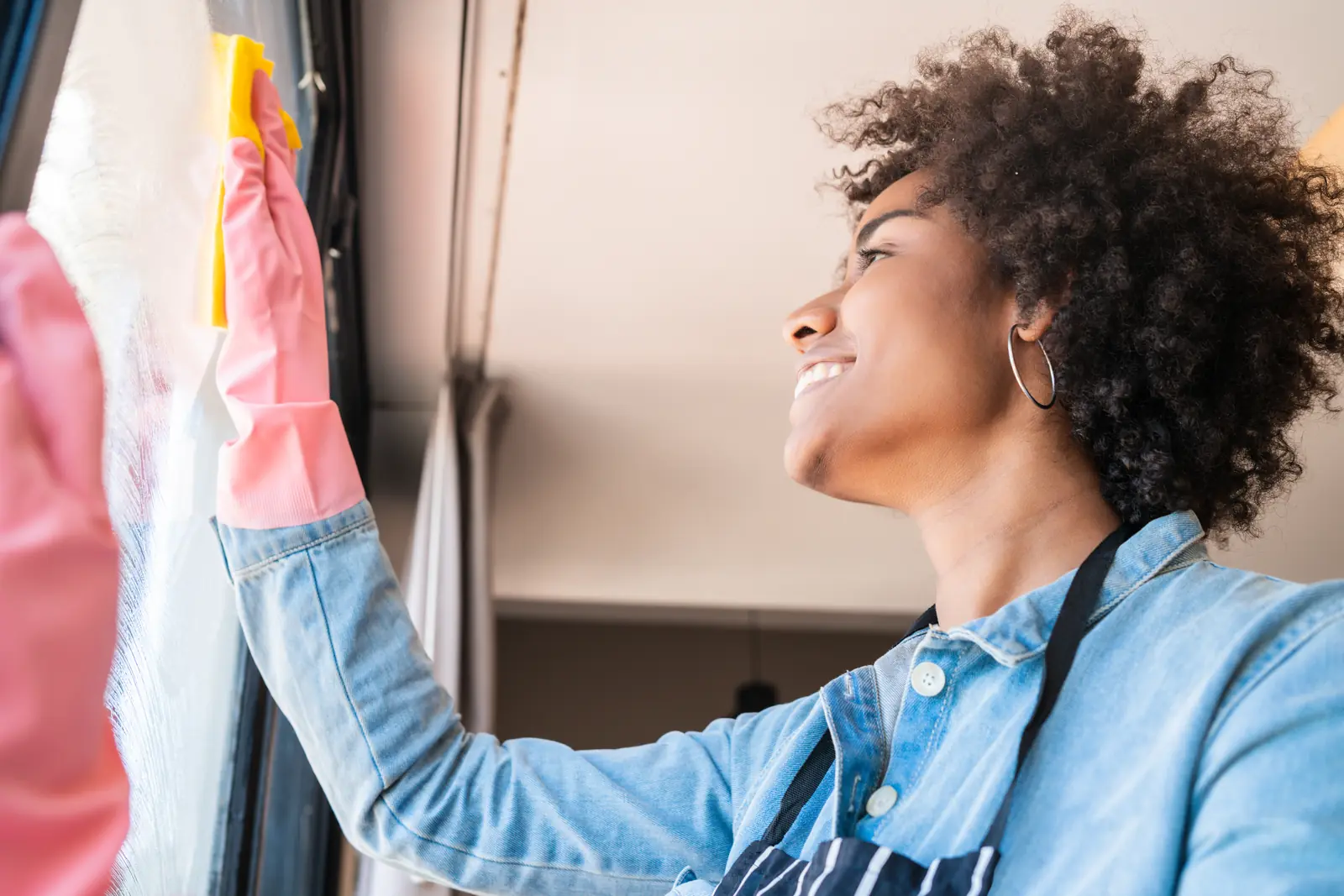 Smiling cleaner wiping a window